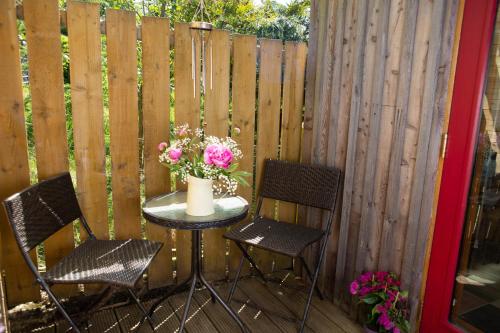 a table with two chairs and a vase of flowers on a patio at Den of Allachlade in Aboyne