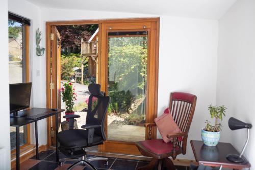 a room with chairs and a sliding glass door at Den of Allachlade in Aboyne