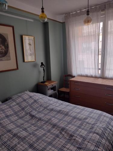 une chambre avec un lit, une commode et une fenêtre dans l'établissement Bright pied-à-terre Eiffel Tower 4 people, à Paris