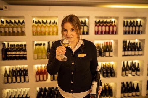 a woman holding a glass of wine in a wine store at Hotel & Restaurant Zum Reussenstein in Böblingen