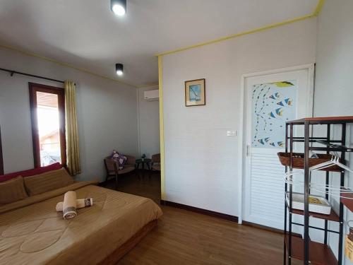 a bedroom with a bed and a living room at Cherlyn Homestay เฌอลินน์โฮมสเตย์ เกาะลิบง in Ban Batubute