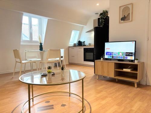 un salon avec une table et une télévision dans l'établissement Apartment for 6 guests in Hypercentre de Rbx, à Roubaix