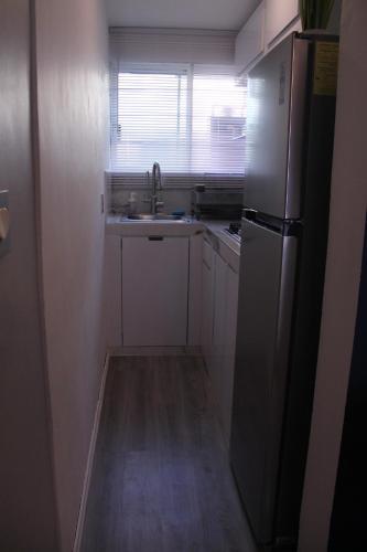 a small kitchen with a sink and a refrigerator at Excelente departamento en jardín Balbuena in Mexico City
