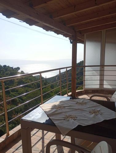 a table on a balcony with a view of the ocean at Apartments Salai in Lukovë