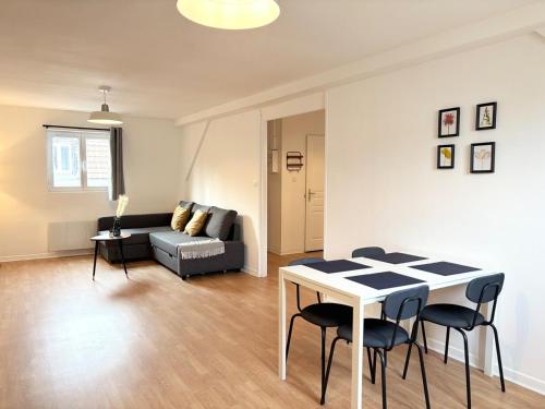 un salon avec une table, des chaises et un canapé dans l'établissement Renovated apartment for 6 guests - Roubaix, à Roubaix