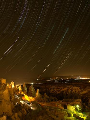 a starry night with trails in the sky over a city at Very Peri Cappadocia - The Lifestyle Luxury Design Hotel in Uchisar