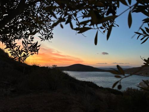 a sunset over a body of water at Delfini Suites in Ano Syros