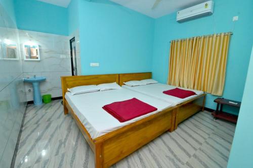 a bedroom with a bed in a blue room at Louis Homestay in Māvalli