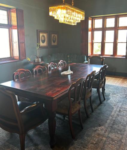 a dining room with a large wooden table and chairs at Rooiheuwel in Botrivier
