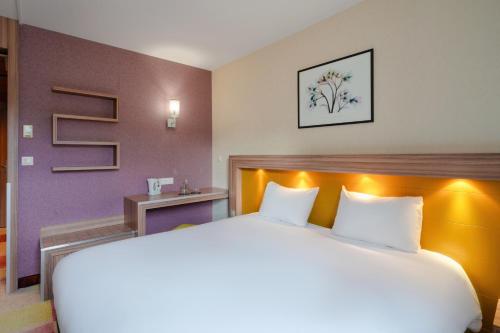 a hotel room with a large bed and a staircase at Mercure Libourne Saint Emilion in Libourne