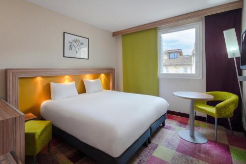 a bedroom with a large bed and a window at Mercure Libourne Saint Emilion in Libourne