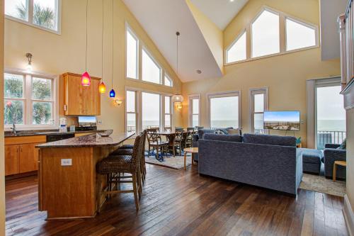 a living room with a kitchen and a living room with windows at The Lighthouse Keeper in Folly Beach