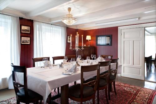 a dining room with a white table and chairs at Hotel Kong Carl - Unike Hoteller in Sandefjord