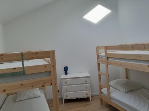 - une chambre avec 2 lits superposés et une table de nuit dans l'établissement Gîte familial 8 couchages proche PuyduFou, à Beaurepaire