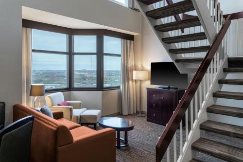 a hotel room with a staircase and a living room at The Capital Suites Hotel in Columbus