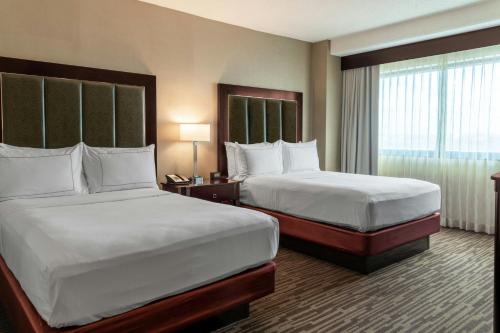 a hotel room with two beds and a window at The Capital Suites Hotel in Columbus