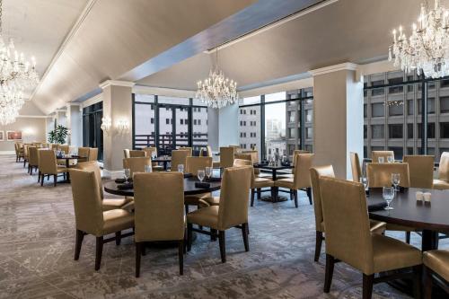 a dining room with tables and chairs and chandeliers at The Capital Suites Hotel in Columbus