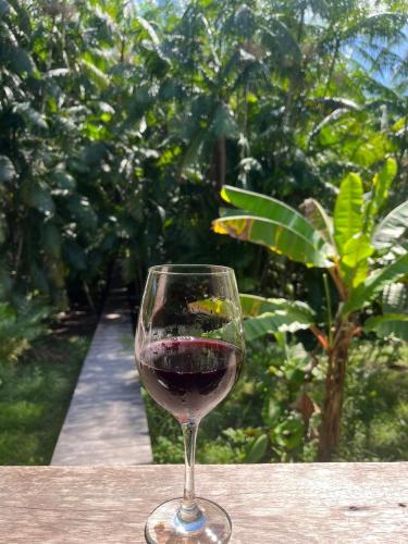 a glass of red wine sitting on a table at Chalé Encantos do Una in Morros