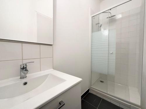 une salle de bain blanche avec un lavabo et une douche dans l'établissement Lovely apartment - 4 guests Roubaix, à Roubaix