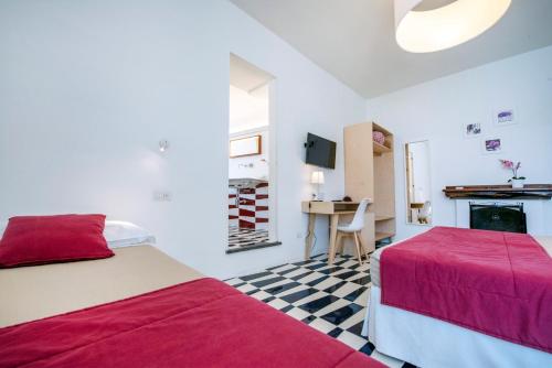 a bedroom with two beds and a table and a fireplace at Le Tre Sirene Rooms in Atrani