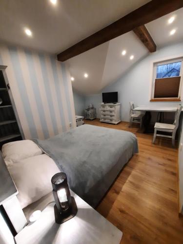a bedroom with a bed and a table with a lamp at Gościna U kowala in Lachowice