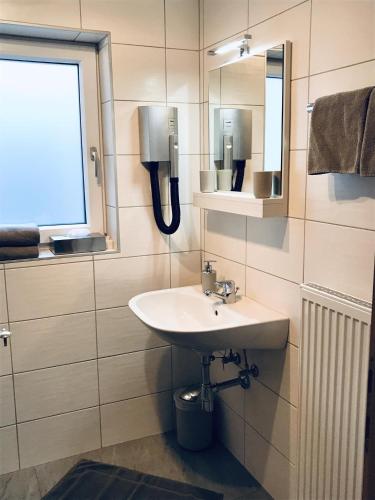 a bathroom with a sink and a mirror at Kössler, Appartementhaus in Bad Hofgastein