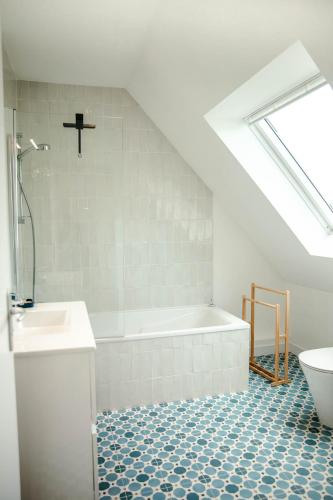 une salle de bain avec une baignoire, des toilettes et un lavabo dans l'établissement Superbe maison pour 6 à 500 m de la mer, à Plouguerneau
