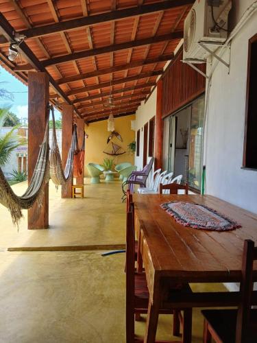 a dining room with a wooden table and chairs at Cantinho do sossego in Trairi