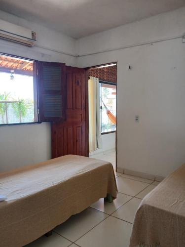 a bedroom with two beds and two windows at Cantinho do sossego in Trairi