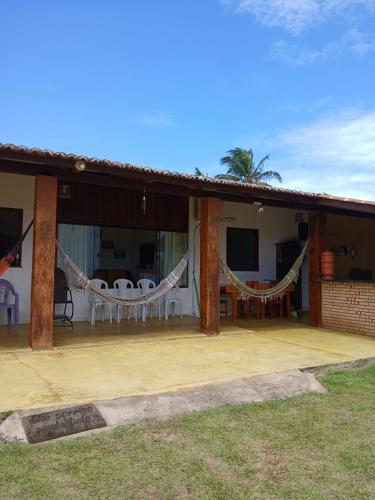 a patio of a house with a table and chairs at Cantinho do sossego in Trairi