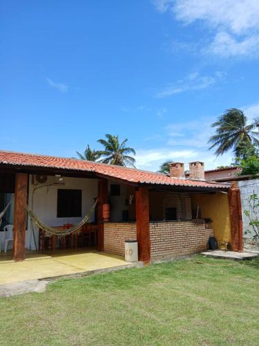 a house with a patio and palm trees at Cantinho do sossego in Trairi