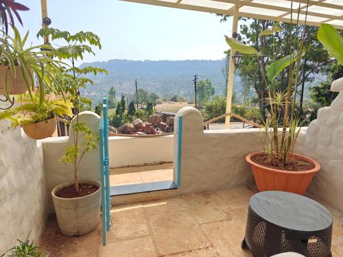 a balcony with potted plants and a mirror at Achalaa Resort in Kolhapur
