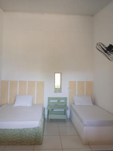 a room with two beds and a table in it at Cantinho do sossego in Trairi