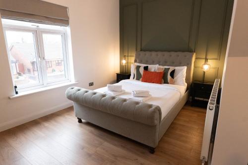 a bedroom with a large bed with a large window at Renovated 3 Bedroom House in Lowton Pennington, free parking in Leigh
