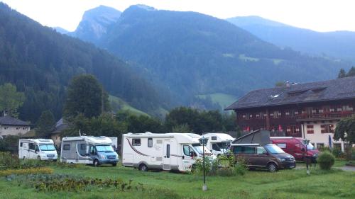 a group of vehicles parked in front of a mountain at Schlosswirts Wohnmobilstellplatz und Schäferwagen in Döllach