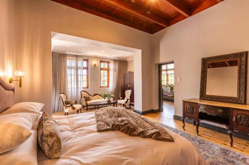 a bedroom with a large bed and a mirror at Rooiheuwel in Botrivier