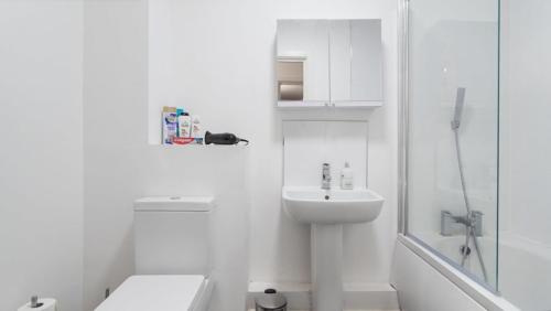 a white bathroom with a toilet and a sink at Affordable 1 & 2 Bed Apartments in Slough, Great Heathrow Location in Colnbrook