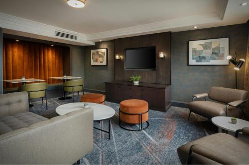 a waiting room with a couch and a tv at Glasgow Marriott Hotel in Glasgow