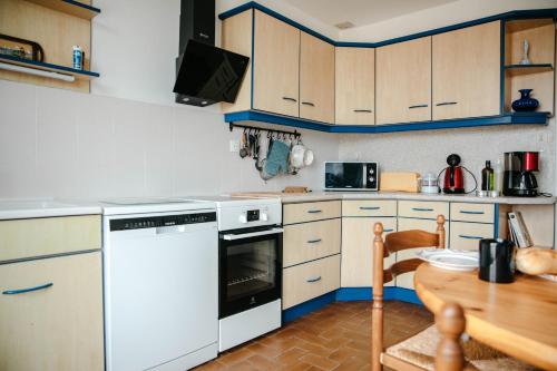 - une cuisine avec des appareils blancs et une table en bois dans l'établissement Belle maison pour 8 sur la plage de Kervenni, à Plouguerneau