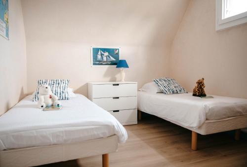 une chambre avec deux lits et une commode dans l'établissement Belle maison pour 8 sur la plage de Kervenni, à Plouguerneau