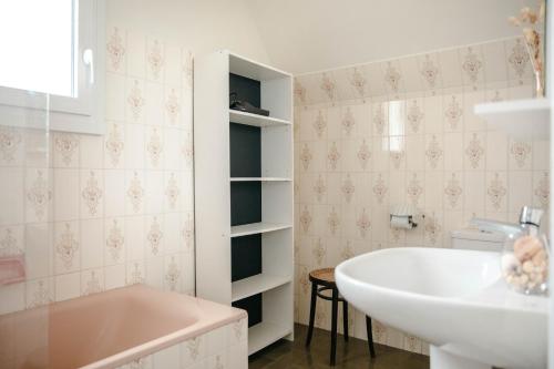 une salle de bain avec une baignoire et un lavabo dans l'établissement Belle maison pour 8 sur la plage de Kervenni, à Plouguerneau