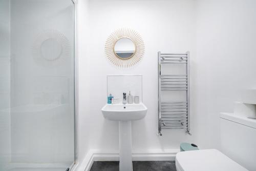 a white bathroom with a sink and a shower at Affordable 1 & 2 Bed Apartments in Slough, Great Heathrow Location in Colnbrook