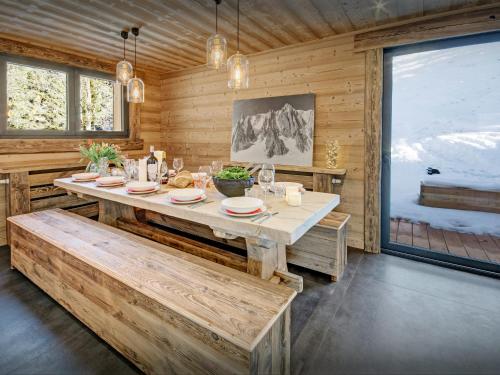 une salle à manger avec une table et une grande fenêtre dans l'établissement Chalet Charmar - OVO Network, à La Clusaz