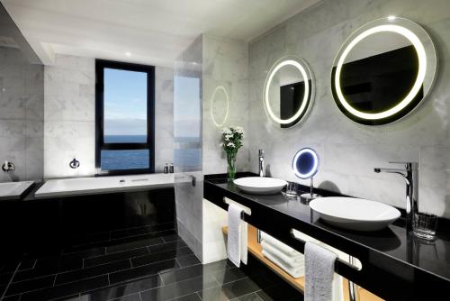 a bathroom with two sinks and two mirrors at Hard Rock Hotel Tenerife in Adeje