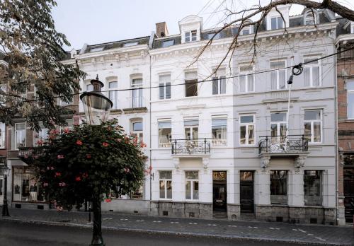a white building with a tree in front of it at W Y C K - E N D boutique hotel in Maastricht