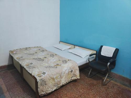 a bed and a chair in a room at Shree Dhaam Homestay in Faizābād