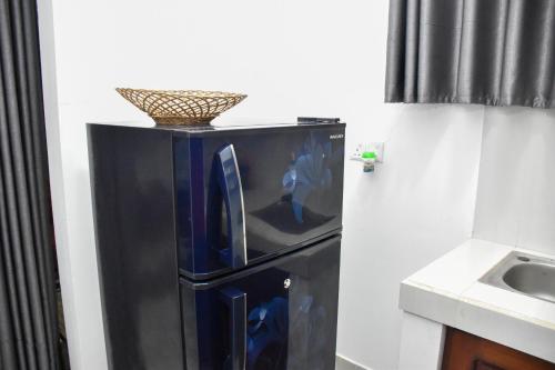 a black refrigerator with a basket on top of it at Cinnamon Mantra Luxury Villa in Beruwala