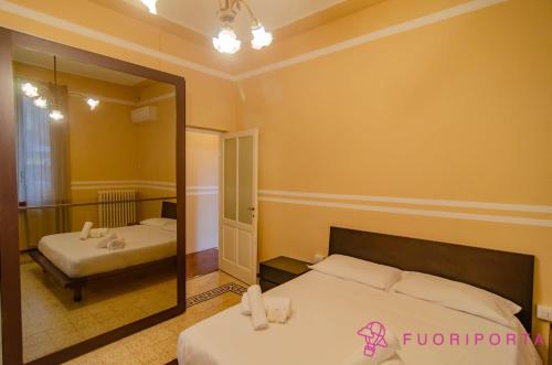 a bedroom with two beds and a mirror at La Magnolia del Ducato in Parma