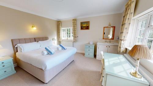 a bedroom with a bed and a desk and a mirror at Hedgerows House New Forest in Ringwood