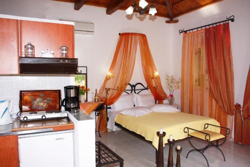 1 dormitorio con 1 cama con cortina naranja en Artemis Bungalows, en Stafylos